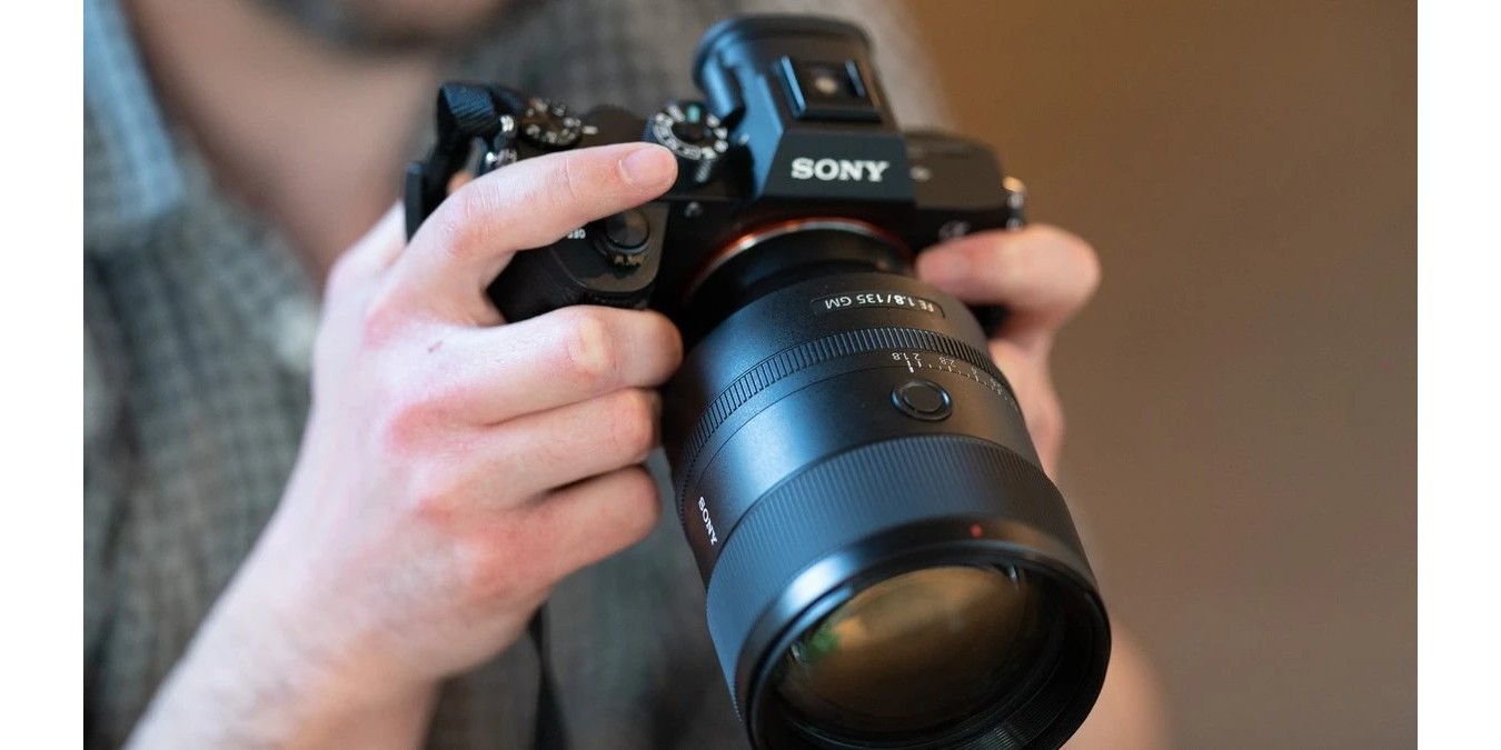 Об'єктив Sony FE 135mm f/1.8 GM у руках фотографа під час портретної зйомки